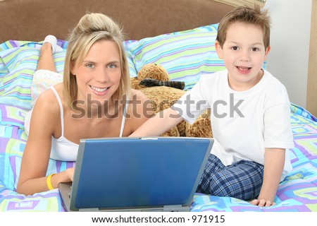 Mother and son with laptop in bed.