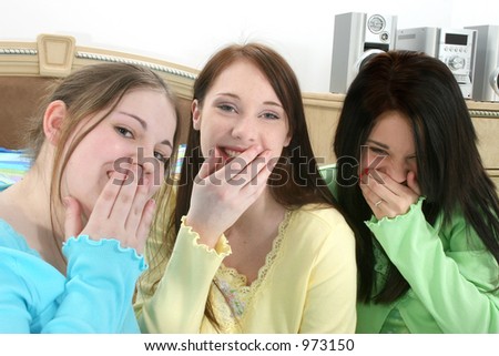 stock photo Three young teen girls in pajamas sitting in bed laughing