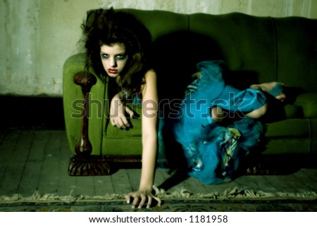 Young girl in goth on old couch.