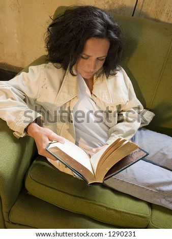 Woman at home in poverty home reading book.