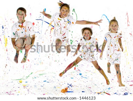Children jumping in paint splattered studio.