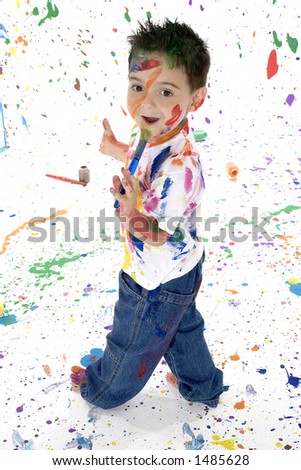 Adorable boy covered in paint splatter on wall floor and self