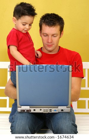 Father and son working on laptop together.
