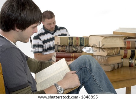 Two men reading through a stack of law books.  Books 70 years old.