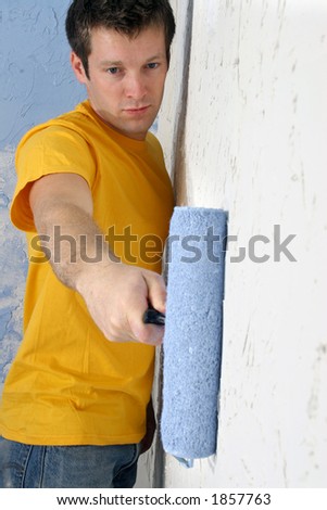Man painting wall blue with roller.