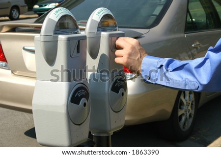 Adult male hand putting money in a parking meter.