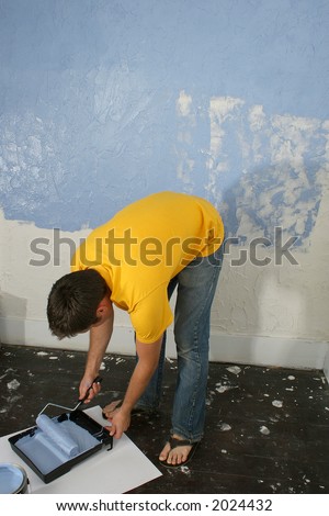 Man painting wall blue.