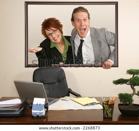 Business couple coming out of frame on office wall.