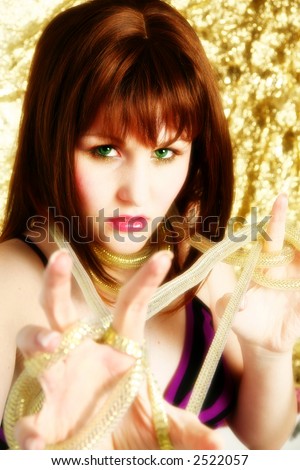 stock photo : Beautiful woman with dark red hair and green eyes on gold 