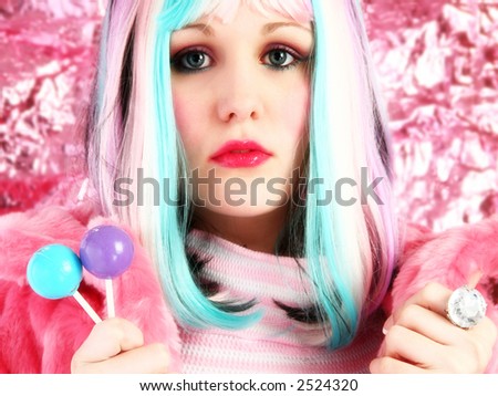 Beautiful young woman in rainbow colored hair with lollipops.