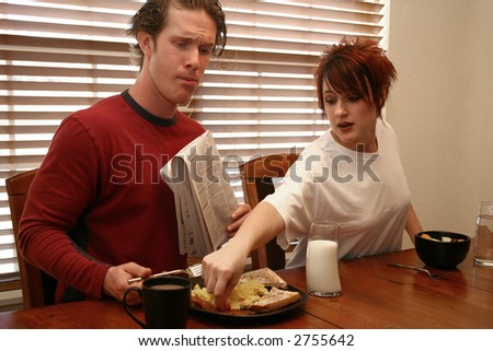 Woman stealing man\'s breakfast.  Attractive thirties couple.