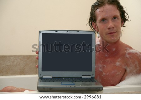 Thirty something man in bubble bath with laptop.  Screen facing camera.