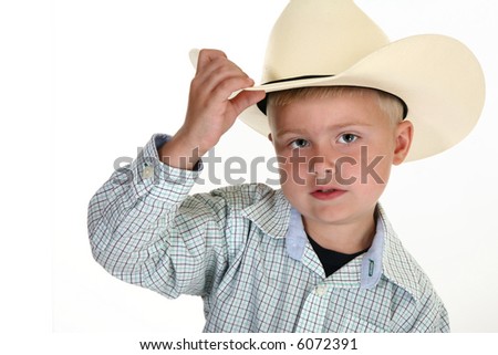 Little American cowboy close up with hat.  No costume here, this kid\'s the real deal and proud of it.