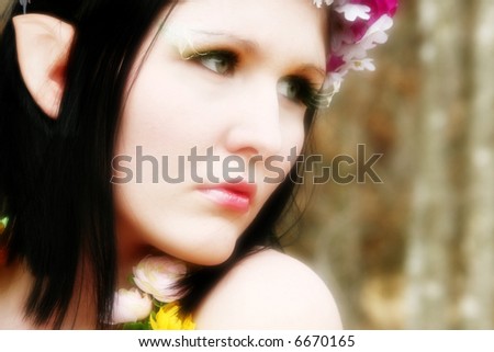 Beautiful young woman dressed as fairy in the woods.