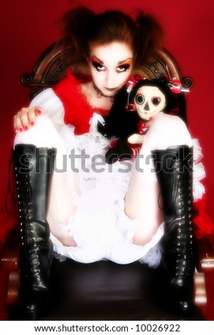 Artistic goth portrait of woman in goth doll dress with matching doll.