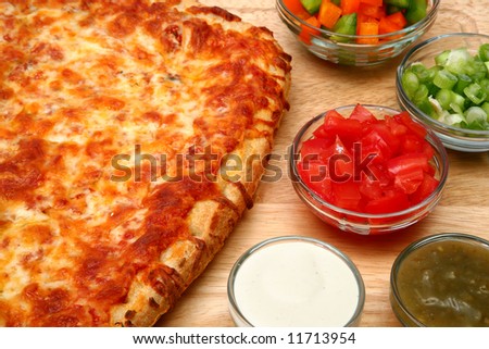 Freadh baked cheese bread pizza and toppings.  Green onion, bell peppers, green salsa, ranch dressing, chopped tomatoes.