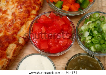 Bowl of diced tomatoes with veggies and cheesebread pizza.