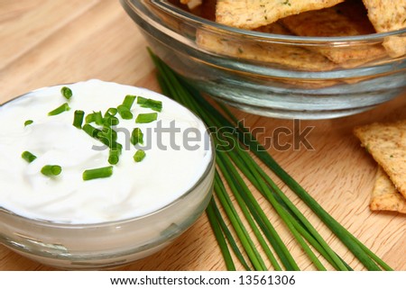 Focus on chives laying between crackers and sour cream.