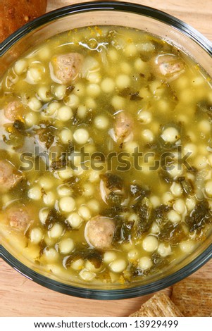 Bowl of hot Italian Wedding Soup (meatballs and spinach soup) in kitchen or restaurant.