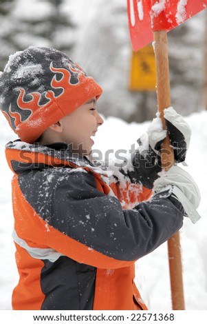 Adorable five year old boy shoveling snow.