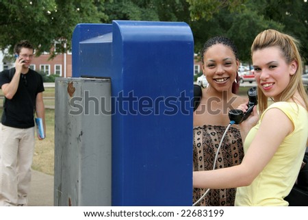 College students on campus at public payphone.