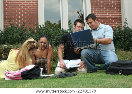 College students on campus.  Study session in the grass.