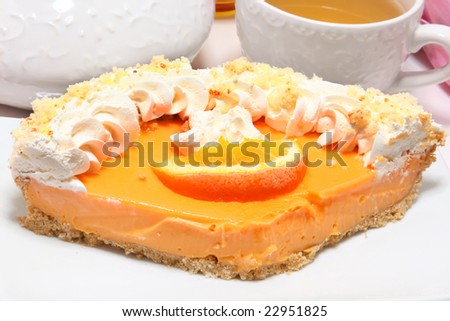 Large piece of tangerine pie with whipped cream and cake crumb garnish.