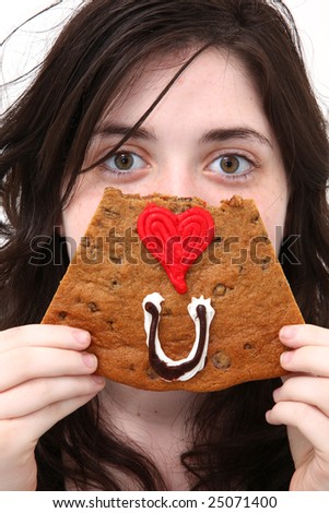 Teen girl spelling out Eye Love You with a cookie in front of face.