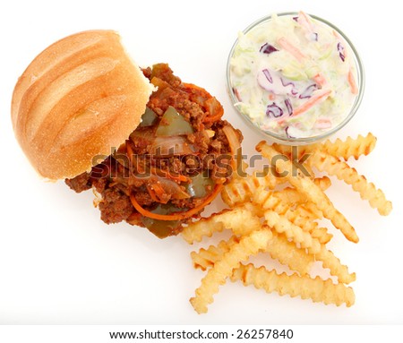 Homemade ground sirlion sloppy Joe with large chunks of vegetables on white with crinkle fries and coleslaw.