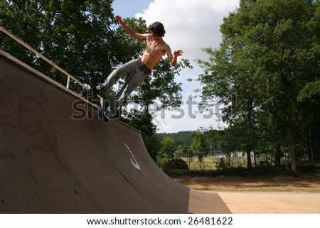 Attractive 16 year old boy on skateboard at skatepark.
