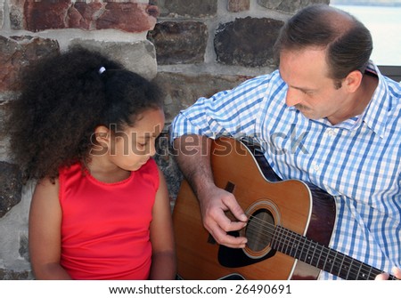 Adorable five year old African American Girl getting guiltar lessons.