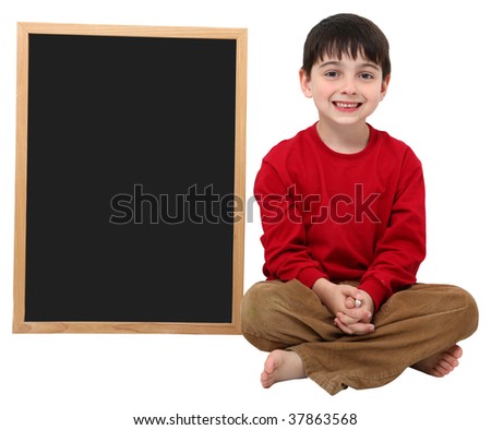 Adorable six year old school boy with blank chalkboard with clipping path over white.