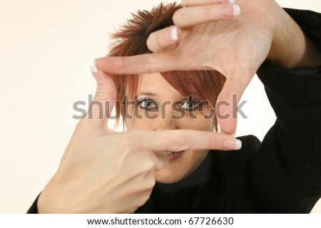 Attractive 30 year old business woman with manicured nails making video camera gesture with hands.