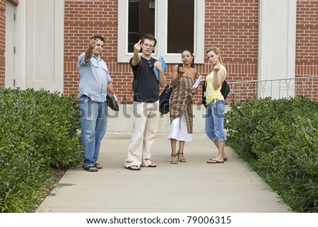 Group of angry college students on campus flipping off camera.