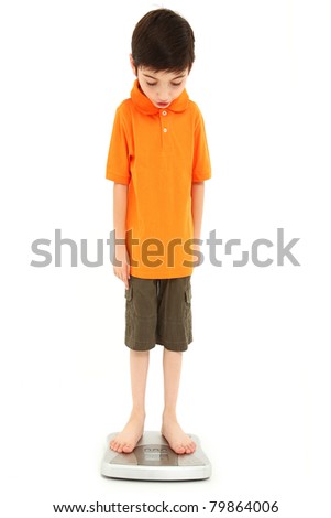 Adorable eight year old boy on scale very thin anorexia nervosa childhood onset concept.