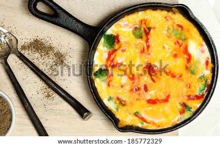 Skillet Baked Eggs with Brocoli, Cheese, Sriracha Sauce on Table.