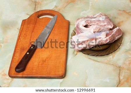 Wooden board with knife and meat