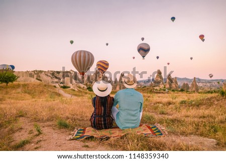 rocky landscape in Cappadocia, Turkey. Hot air ballooning in morning is most amazing attraction in Kapadokya during Sunrise, happy young couple on vacation in Goreme Cappadocia