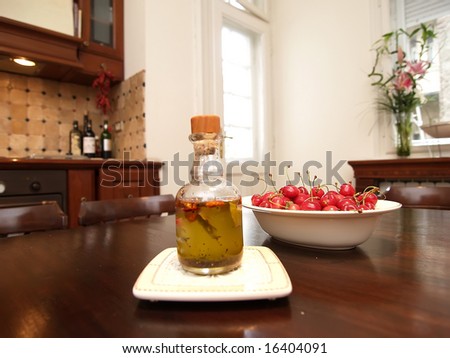 olive oil and dish with cherry on kitchen table
