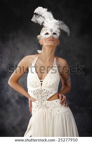 beautiful woman in wedding dress holding mask