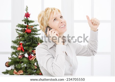 Business woman with mobile phone and christmas tree
