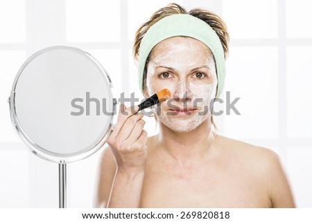 Forty years old woman
putting mask on face