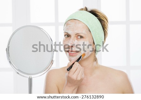 Forty year old woman putting mask\
on her face