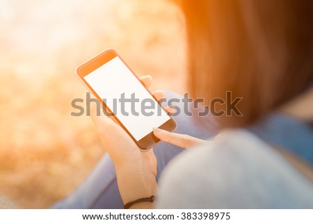 girl with smartphone outdoors in park. Closeup of female hands and smart phone with isolated white screen  ,sunlight