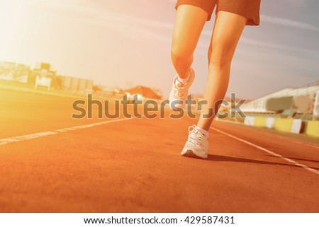 Sports woman running on tracks Female jogging. Woman jogging on sunset. Woman running on a running track. running shoes. Woman running and jogging concept. Girl running from Thailand. Fitness health.
