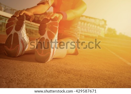 Young woman stretching on a running track. Woman jogging on sunset. Woman running on a running track. running shoes. Woman running and jogging concept. Girl running from Thailand. Fitness health.