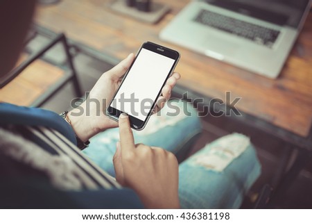 girl using smartphone in cafe. smartphone white screen. hand holding smartphone.  black color smartphone. vintage tone.