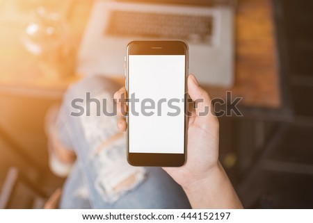 girl using smartphone in cafe. smartphone white screen. hand holding smartphone on sunset.