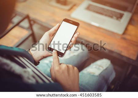 girl using smartphone in cafe. smartphone white screen. hand holding smartphone. black color smartphone on vintage tone.
