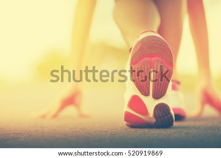 Runner feet running on road closeup on shoe. woman fitness sunrise jog workout welness concept on sunset. Vintage tone.